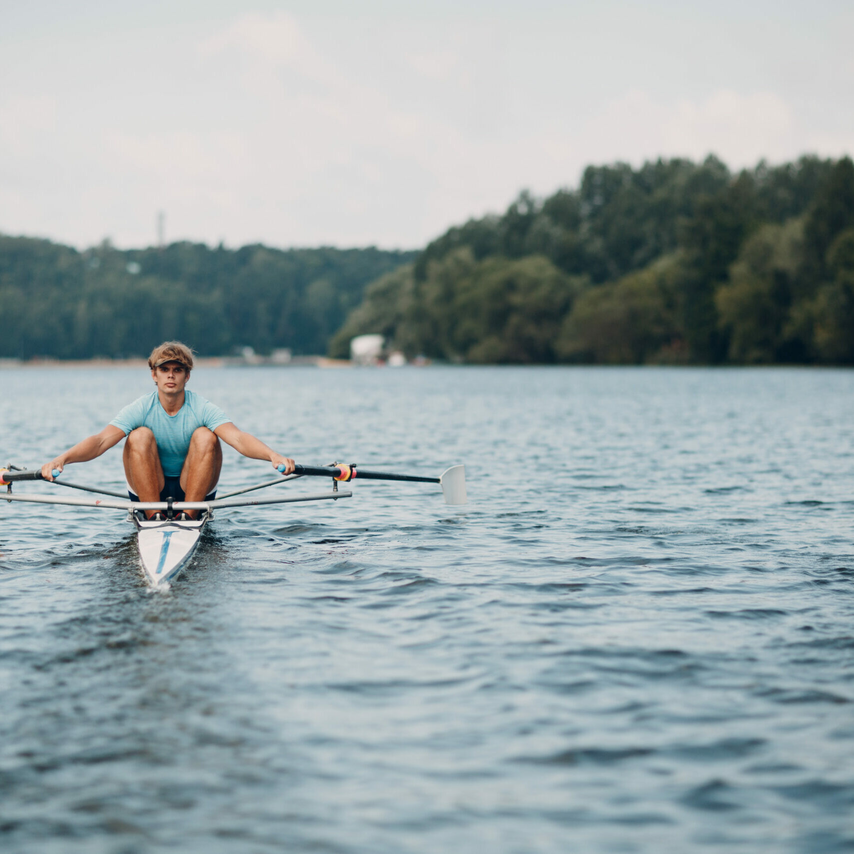 Sportsman single scull man rower rowing technique on boat. Paddle oar splash movement